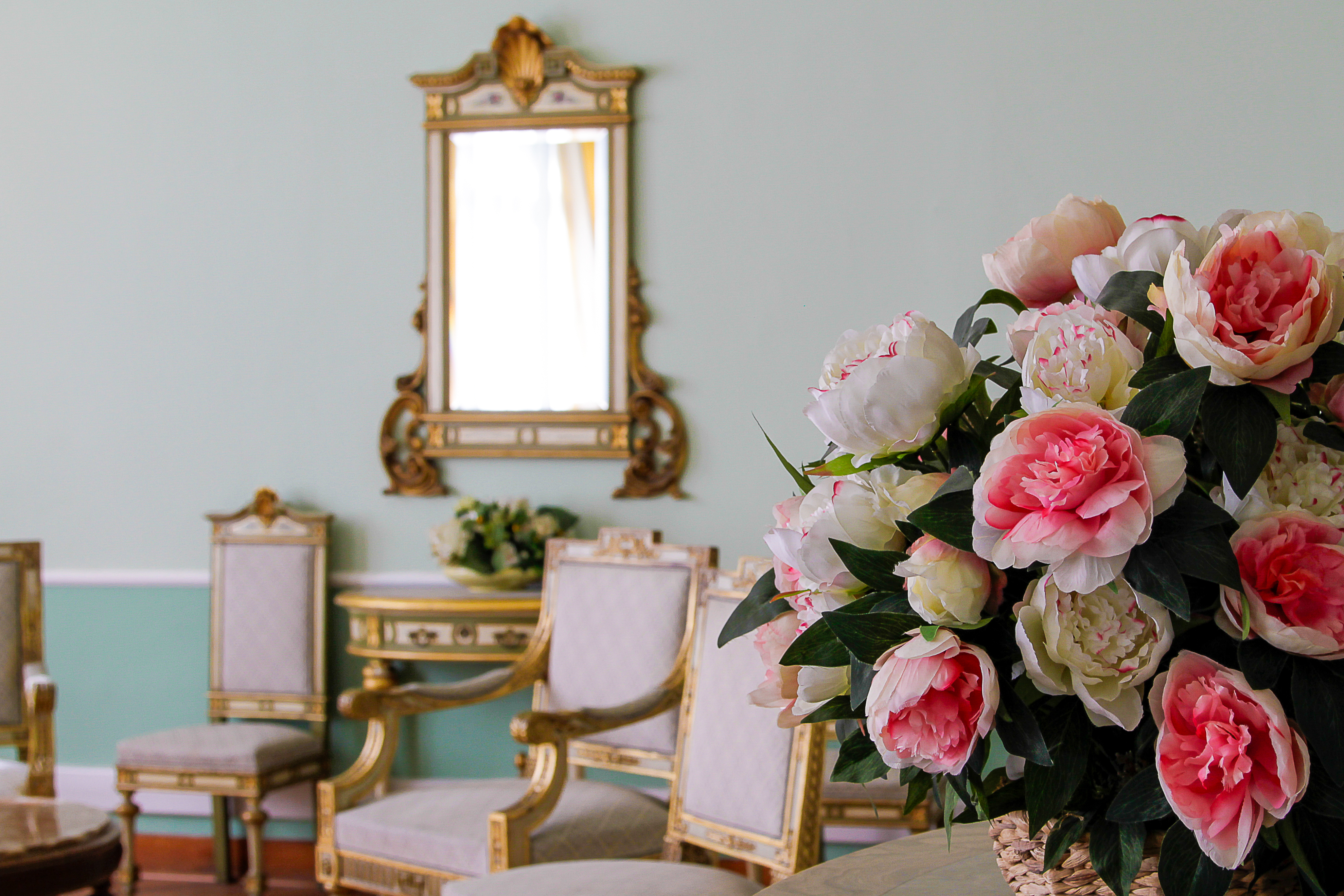 Immagine che contiene fiori in primo piano, uno specchio e delle sedie presenti all' interno della sala cerimonie di Corso Torino