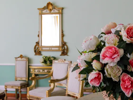 Immagine che contiene fiori in primo piano, uno specchio e delle sedie presenti all' interno della sala cerimonie di Corso Torino